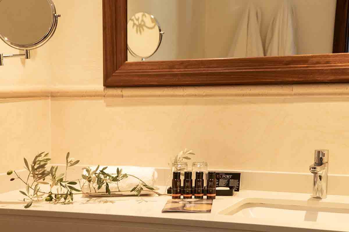 Bathroom sink and mirror in guest bedroom at Hotel Es Port in Spain.