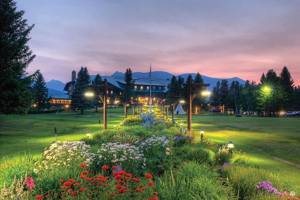 large lawn and gardens at night in front of Glacier Lodge