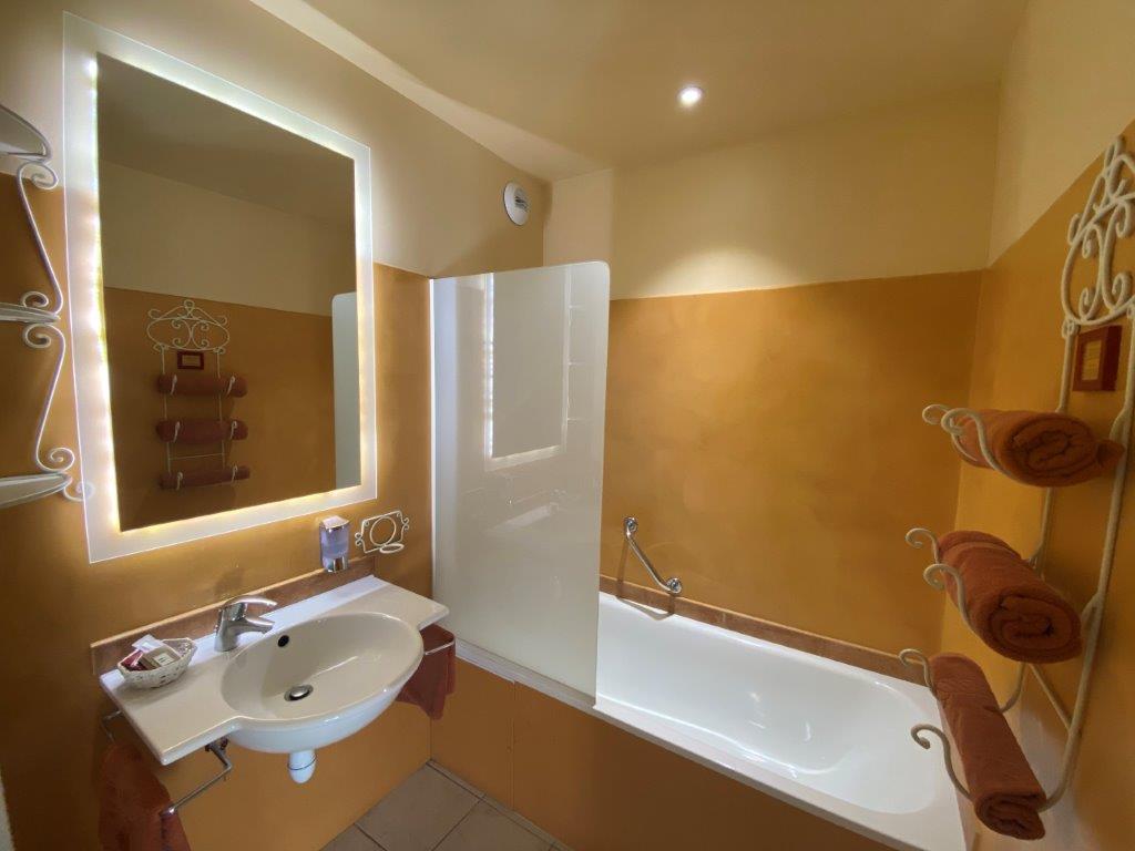 Bathtub and sink in bathroom at Hotel Les Sables d'Ocre