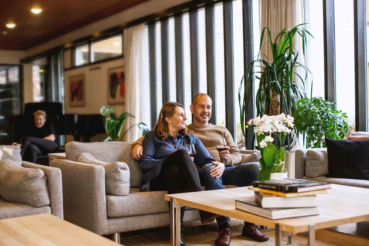 Husband and wife relaxing on sofa at Lindstrom Hotel in Norway