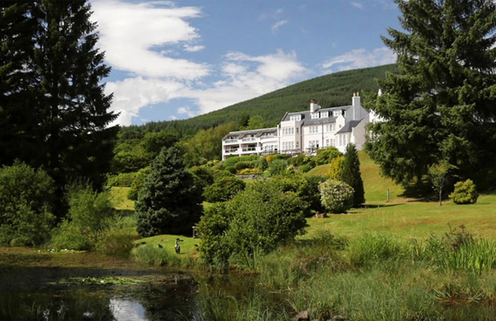 Hotel exterior with forested hill in the background