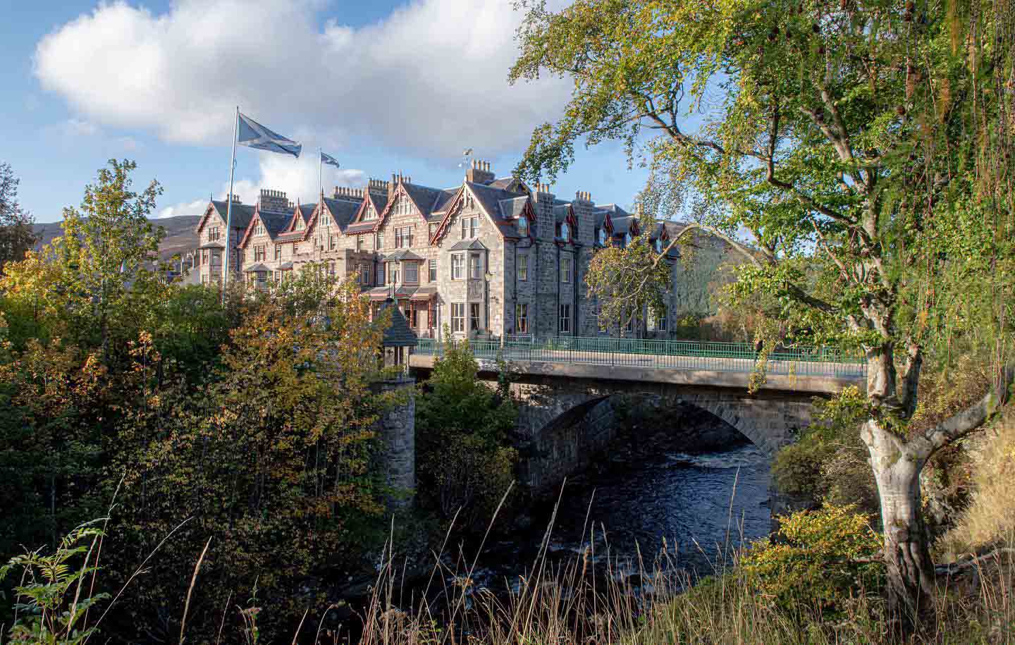 Bridge over the river leading to the exterior of The Fife Arms hotel in Scotland