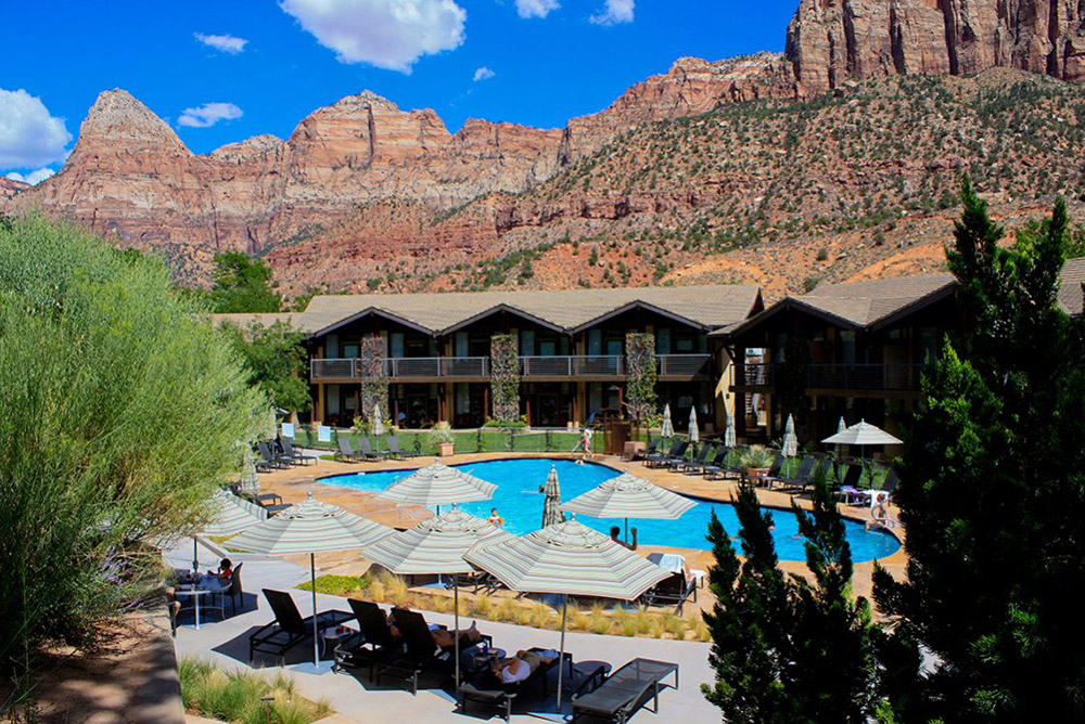 desert pearl inn exterior pool with tall cliffs in the background