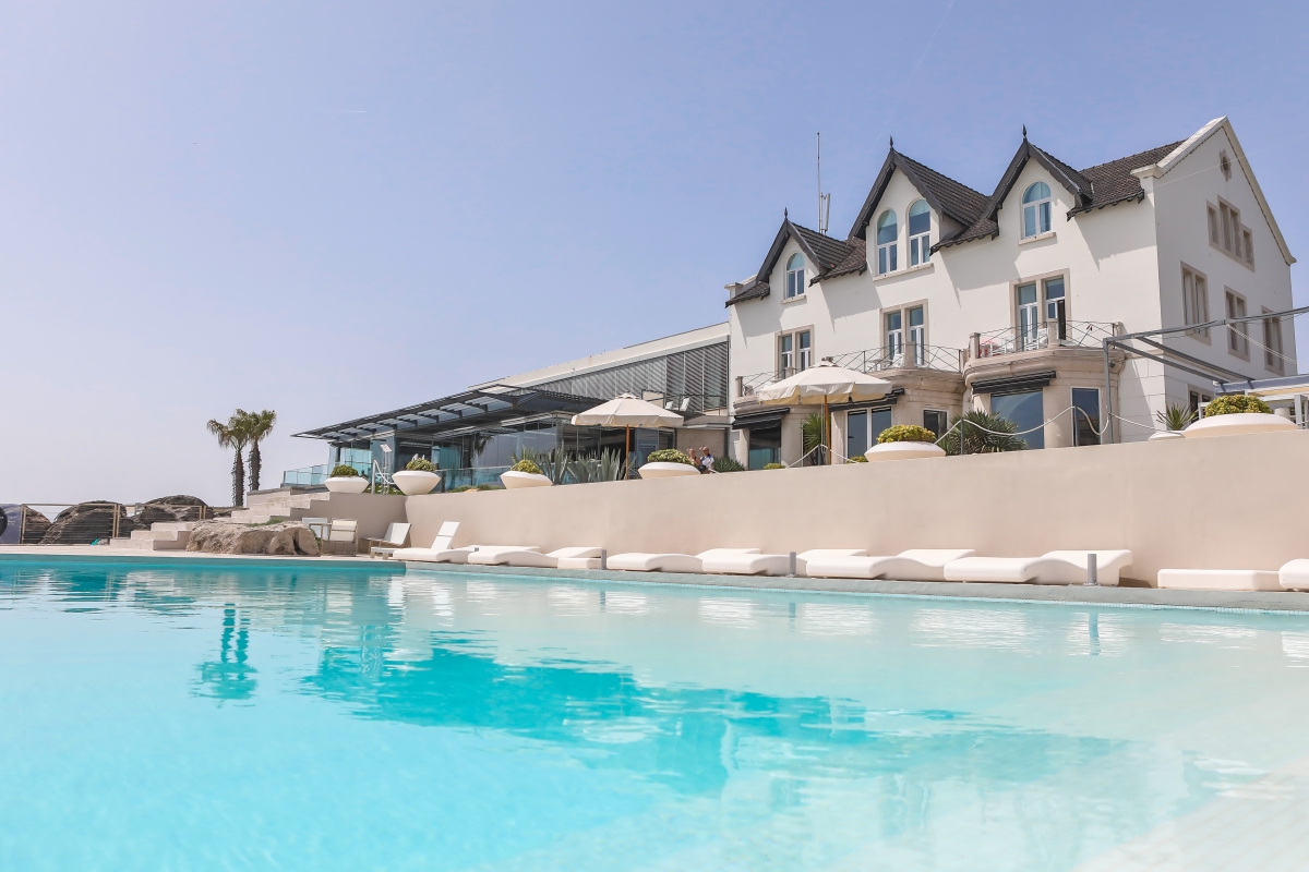 Pool with hotel in background at Farol Hotel