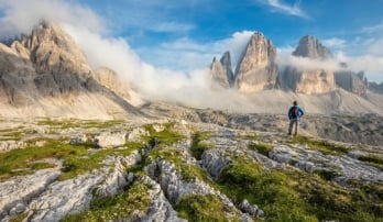 Hiker standing on a trail overlooking the Dolomites in South Tirol, Italy