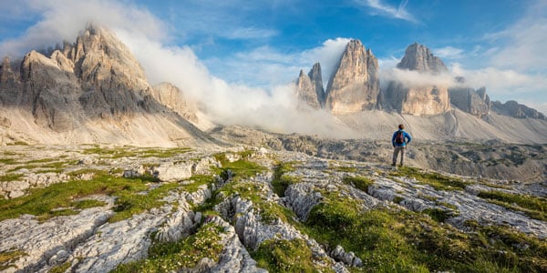 Hiker standing on a trail overlooking the Dolomites in South Tirol, Italy