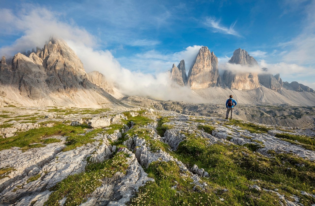 Hiker standing on a trail overlooking the Dolomites in South Tirol, Italy