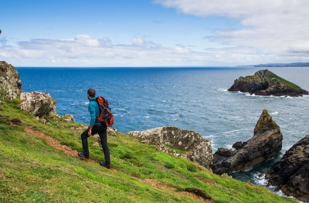 Solo traveler exploring the rocky coastline in Cornwall, England