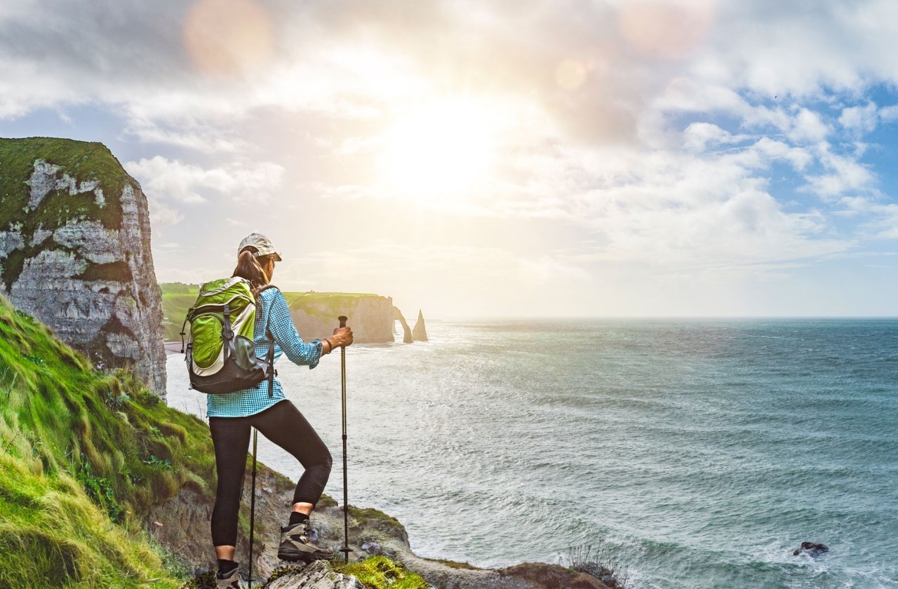 A woman hiking on the mountains next to the water