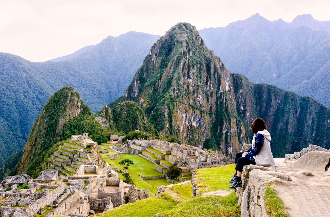 Hiker pausing on a trail with views of Machu Picchu in Peru