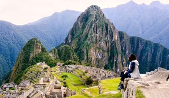 Hiker pausing on a trail with views of Machu Picchu in Peru