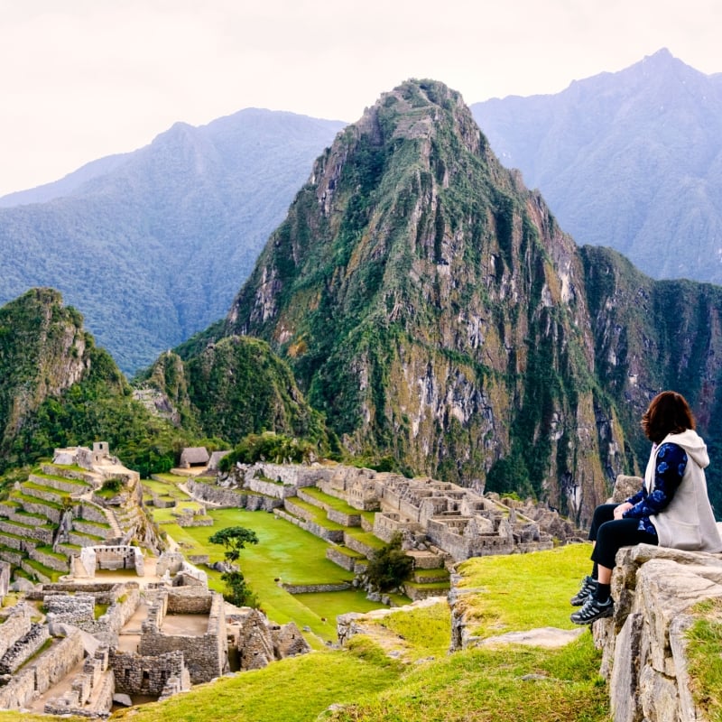 Hiker pausing on a trail with views of Machu Picchu in Peru