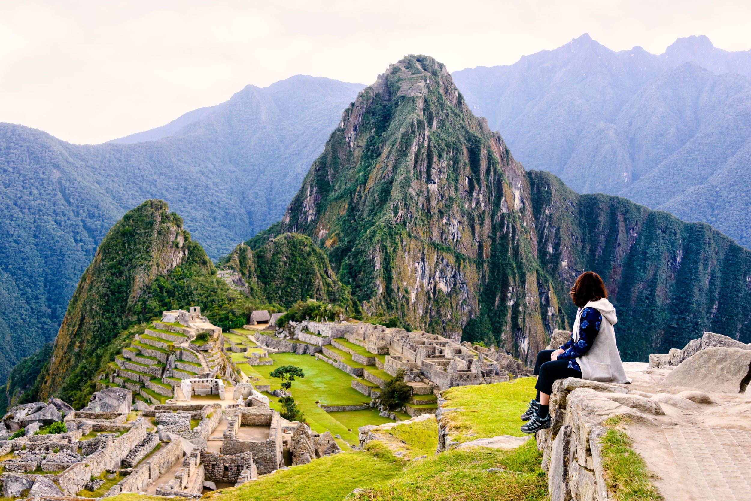 Hiker pausing on a trail with views of Machu Picchu in Peru