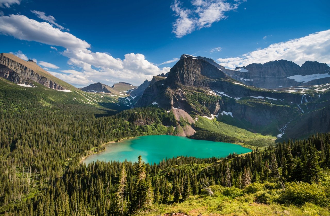 Scenic view of a lush mountain valley and lake at Glacier National Park