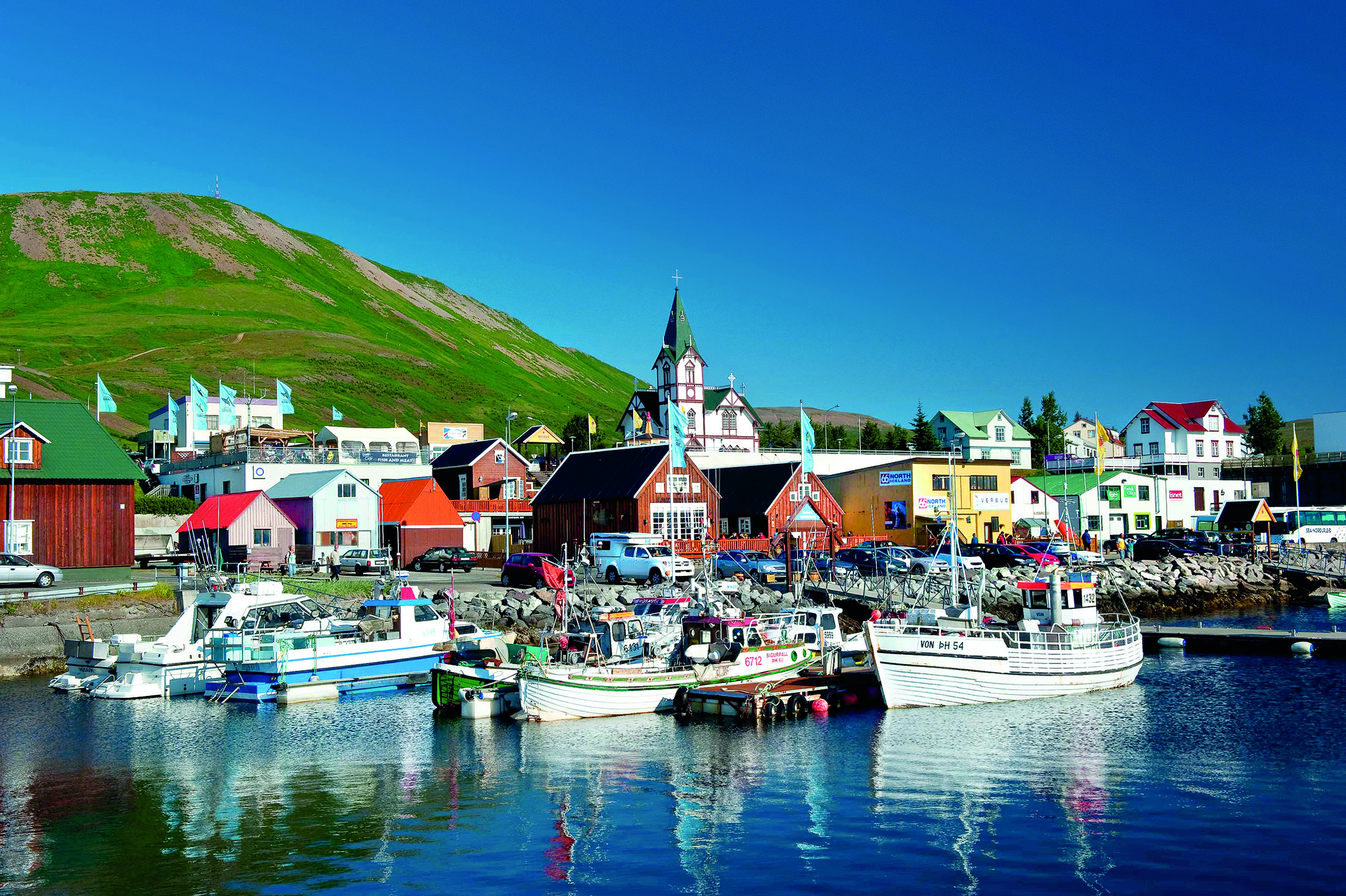 Boats on water near homes in Iceland